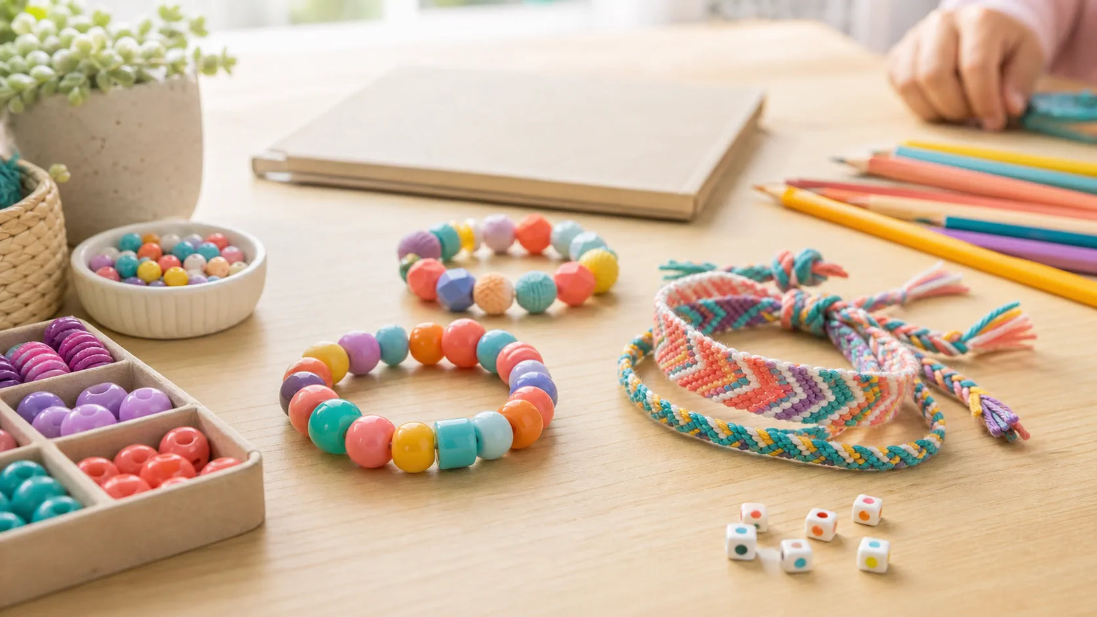 Colorful back-to-school bracelets beside pencils and a notebook on a kids craft table